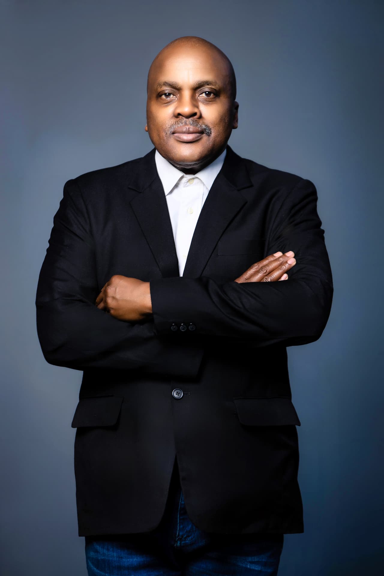 Vuyo Bavuma, Executive Director, standing with folded arms in a black jacket and white shirt